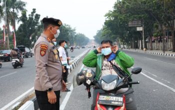 Antisipasi Dampak Asap Karhutla, Polda Riau Bagikan 2.500 Masker kepada Warga Pekanbaru